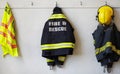 Fireman, uniform and clothing hanging on wall rack at station for fire fighting protection. Firefighter gear, rescue