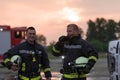 fireman using walkie talkie at rescue action fire truck and fireman's team in background.