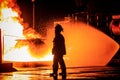 Fireman walking in front of fire