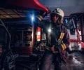 A fireman wearing a protective uniform with flashlight included working in a fire station garage