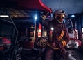 A fireman wearing a protective uniform with flashlight included working in a fire station garage