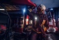 A fireman wearing a protective uniform with flashlight included working in a fire station garage