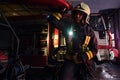 A fireman wearing a protective uniform with flashlight included working in a fire station garage