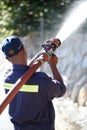 Fireman at work. Rearview shot of a fireman spraying water with a fire hose.