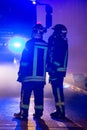 Firemen direct water stream on burning house.building in full flaming inferno, and a firefighter fighting to get control of the fl Royalty Free Stock Photo