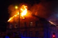 Firemen direct water stream on burning house.building in full flaming inferno, and a firefighter fighting to get control of the fl Royalty Free Stock Photo