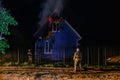 Firemen extinguish fire in rural house at night