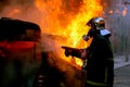 Firemen fighting a flaming car after an explosion Royalty Free Stock Photo