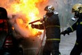 Firemen fighting a flaming car after an explosion Royalty Free Stock Photo