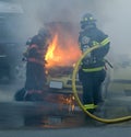 Firemen putting out a car on fire