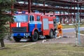 Firemen rescue workers in fireproof suits came to extinguish a fire in a fire truck and stretch the hoses in a large industrial Royalty Free Stock Photo