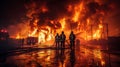 Firemen Standing in Front of Huge Fire Royalty Free Stock Photo