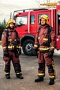 Firemen standing next to fire truck. Royalty Free Stock Photo