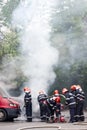 Firemen team extinguishing a car on fire