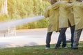 Firemen using extinguisher and water from hose for fire fighting
