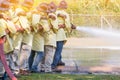 Firemen using extinguisher and water from hose for fire fighting