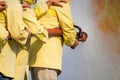 Firemen using water from hose for fire fighting at fire fight training of insurance group.Firefighter wearing a fire suit for