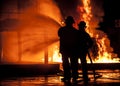 Firemen using water hose on raging fire