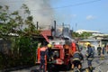 Firemen and volunteers working assembling fire hoses in fire truck in the area of a burning house Royalty Free Stock Photo