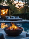Firepit by a poolside at sunset with lounge chairs. Royalty Free Stock Photo