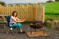Woman warming her hands, via a firepit whilst glamping, in Cumbria. Royalty Free Stock Photo