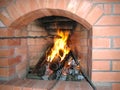 Fireplace of brick in the house preparing sausage on a branch