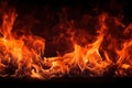 Fireplace of burning powerful fire with black coals, burnt wood in flames of fire, dynamic bright background with copy Royalty Free Stock Photo