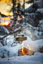 Fireplace and coffee pot in Finland. There is a sunset in the background.