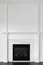 A fireplace detail with decorative trim, marble surround, and shiplap. Royalty Free Stock Photo