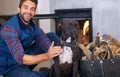 Fireplace, dog and portrait of man with fire in home for heat, warmth and light in winter. Flame, wood and person with Royalty Free Stock Photo