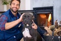 Fireplace, dog and portrait of man in home with fire for heat, warmth and light in winter. Flame, wood and person with Royalty Free Stock Photo