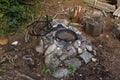 Fireplace with empty brass pot and empty black grill between grey stones and brown forest floor, fireplaces offer hikers a cooking Royalty Free Stock Photo