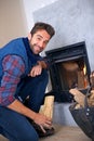 Fireplace, happy and portrait of man in home with fire for heat, warmth and light in winter. Flame, hearth and person Royalty Free Stock Photo