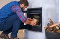 Fireplace, hearth and man with wood for fire for heat, warmth and light in winter in home. Flame, burning and person Royalty Free Stock Photo