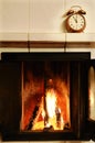 Fireplace and old-fashioned copper alarm clock on the mantelshe Royalty Free Stock Photo