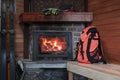 Fireplace in ski forest lodge with tourist backpack and ski. Wnter hut in mountains ski resort. Relaxation, winter sport Royalty Free Stock Photo