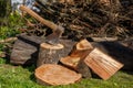 Firewood with an ax in a clearing with green grass Royalty Free Stock Photo