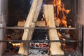 Firewood is burning in fireplace behind metal grate closeup Royalty Free Stock Photo