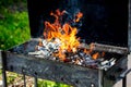 Firewood burns in a metal grill