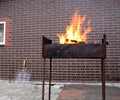 Firewood and fire in the old rusty charcoal grill