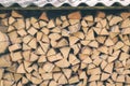 Firewood or fuelwood stacked by a wall. Wooden pile prepared for winter. Fuel for countryside fireplace. Forest timber Royalty Free Stock Photo