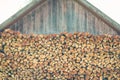 Firewood or fuelwood stacked by a wall. Wooden pile prepared for winter. Fuel for countryside fireplace. Forest timber