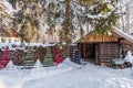 A warm looking cottage at the middle of a snowy winter forest. Firewood stacked in piles, covered with snow. cutted Royalty Free Stock Photo