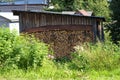 The firewood is stacked in a woodpile against the wall of a wooden shed Royalty Free Stock Photo