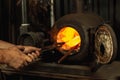 Close-up working powerful hands of male blacksmith making red hot metal in furnace, horn. Work process of heating metal