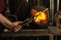 Close-up working powerful hands of male blacksmith making red hot metal in furnace, horn. Work process of heating metal