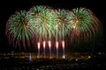 Fireworks. Colorful different amazing fireworks with the moon, dark sky background and house light in the far in Zurrieq, Malta