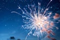 Fireworks display in night sky with scattered clouds over blue backdrop. Royalty Free Stock Photo