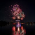Fireworks exploding over a calm lake, reflection shimmering in the water Royalty Free Stock Photo