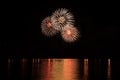 Fireworks festive celebration light show at night over the water. Royalty Free Stock Photo